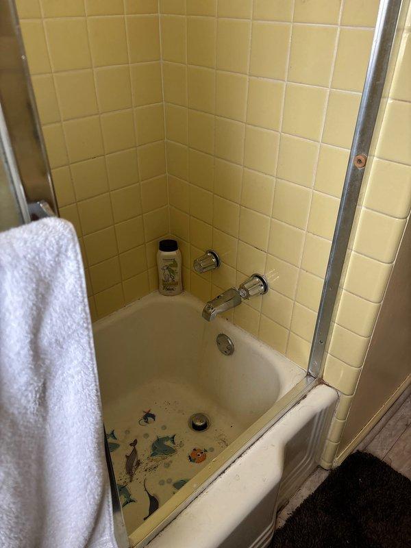 Completed comprehensive plumbing inspection and assessment of bathroom fixtures in preparation for scheduled full home repairs. Documented existing conditions of bathtub/shower area with yellow tile surround, chrome fixtures, and vanity area with beige tile countertop and undermount sink to establish baseline for upcoming five-hour repair service.