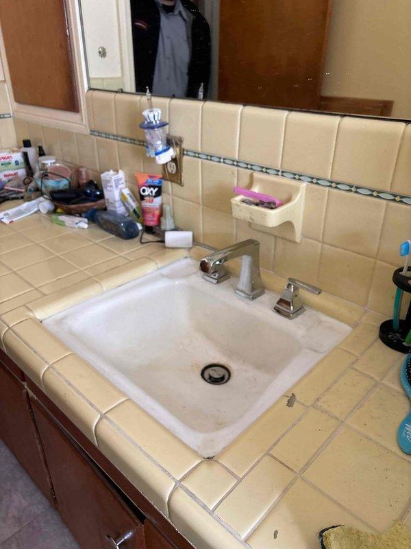 Completed comprehensive plumbing inspection and assessment of bathroom fixtures in preparation for scheduled full home repairs. Documented existing conditions of bathtub/shower area with yellow tile surround, chrome fixtures, and vanity area with beige tile countertop and undermount sink to establish baseline for upcoming five-hour repair service.