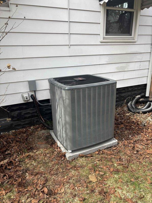Completed full furnace replacement and new air conditioning system installation at residential property. Installed new gas furnace unit in basement mechanical room with proper venting via white PVC piping, mounted on platform with all required safety labels and specifications clearly visible. Added new outdoor AC condenser unit on concrete pad with electrical disconnect box, conduit run along exterior wall, and refrigerant line set connecting to indoor air handler. All ductwork connections completed, system tested and verified operational.