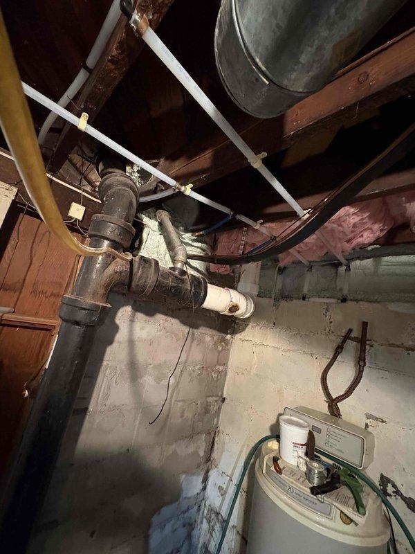 Completed installation of a 40-gallon natural draft natural gas water heater with 6-year tank and 1-year parts warranty. Performed complete water supply repipe utilizing new PEX or copper distribution lines to replace aging galvanized or deteriorated piping throughout the structure. Installed new gas supply line connection to water heater with proper sediment trap and shut-off valve. Mounted unit in basement utility area against concrete block wall with appropriate clearances for combustion air and venting. Connected temperature and pressure relief valve with proper discharge piping terminating safely near floor level. Installed new cold water supply line with shut-off valve and new hot water outlet distribution. Secured all piping to floor joists using appropriate hangers and strapping. Ensured proper venting configuration for natural draft appliance with adequate rise and support. Tested all connections for leaks, verified gas pressure, and confirmed proper burner ignition and operat