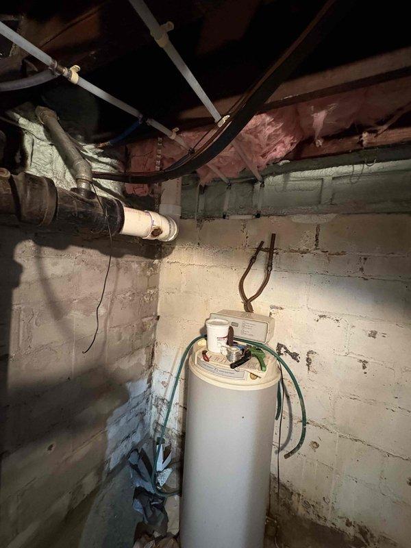 Completed installation of a 40-gallon natural draft natural gas water heater with 6-year tank and 1-year parts warranty. Performed complete water supply repipe utilizing new PEX or copper distribution lines to replace aging galvanized or deteriorated piping throughout the structure. Installed new gas supply line connection to water heater with proper sediment trap and shut-off valve. Mounted unit in basement utility area against concrete block wall with appropriate clearances for combustion air and venting. Connected temperature and pressure relief valve with proper discharge piping terminating safely near floor level. Installed new cold water supply line with shut-off valve and new hot water outlet distribution. Secured all piping to floor joists using appropriate hangers and strapping. Ensured proper venting configuration for natural draft appliance with adequate rise and support. Tested all connections for leaks, verified gas pressure, and confirmed proper burner ignition and operat