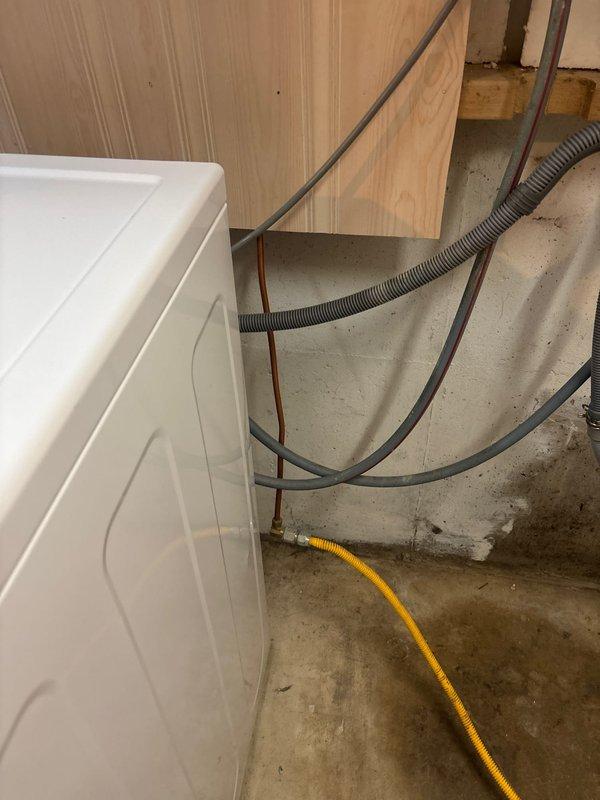 Completed project estimate for installation of shutoff valve on gas line in a sixty-year-old residential property. Assessment revealed existing yellow flexible gas line running through basement utility area near laundry appliances, requiring proper shutoff valve installation for safety compliance and code requirements. Documentation captured existing conditions including copper piping, HVAC ductwork, and gas line routing along concrete floor and wall surfaces.