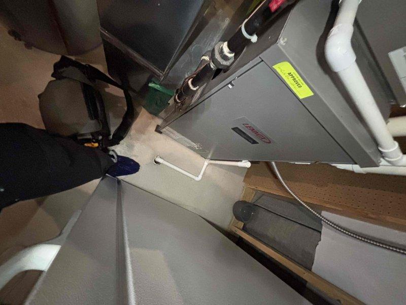 Responded to service call for 10-year-old water heater not heating as well as expected. Performed diagnostic inspection of water heating system in basement utility area, documenting equipment condition and installation configuration. Assessed HVAC equipment, associated piping systems including PVC and copper refrigerant lines, and overall mechanical room setup to identify potential issues affecting heating performance.