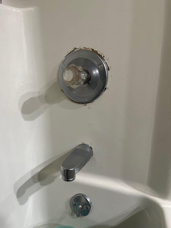 Completed installation of new shower valve assembly in bathtub enclosure, replacing previous deteriorated unit that showed significant corrosion and rust staining around the escutcheon plate. The new chrome single-lever shower control valve was properly installed and tested for functionality, with all connections secured and verified leak-free.