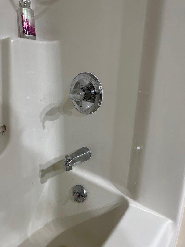 Completed installation of new shower valve assembly in bathtub enclosure, replacing previous deteriorated unit that showed significant corrosion and rust staining around the escutcheon plate. The new chrome single-lever shower control valve was properly installed and tested for functionality, with all connections secured and verified leak-free.