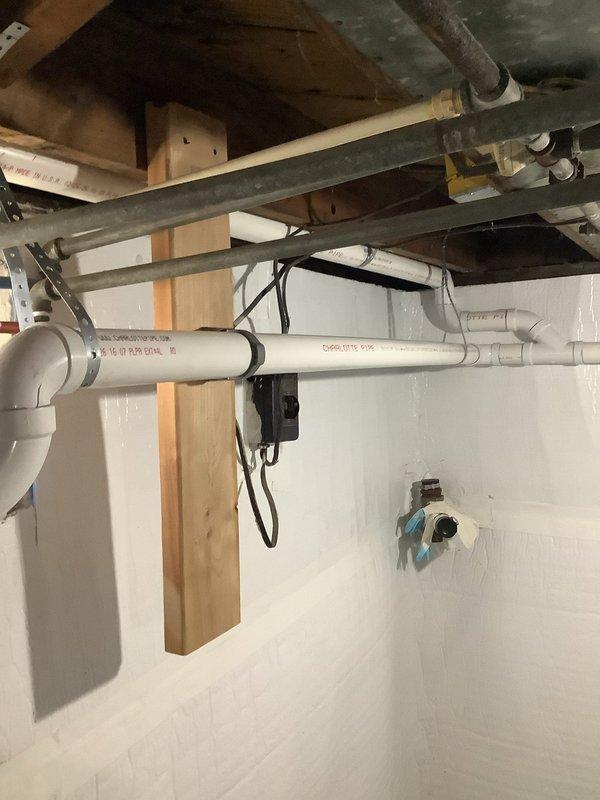 Completed repipe of laundry and kitchen sink drain lines in basement area. Installed new PVC drain piping with proper P-trap assembly and horizontal waste lines, secured to floor joists with appropriate hangers and supports. All connections made to code specifications with proper slope for drainage, ensuring reliable waste water removal from both fixtures.
