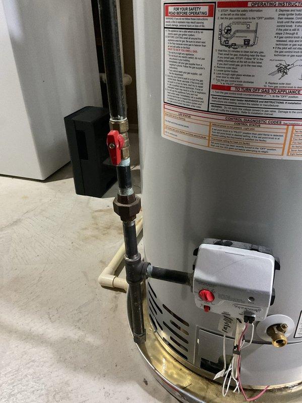 Responded to report of slow drip leak on 10-year-old Bradford White residential water heater. Upon inspection, unit was still operational with minor leak present at bottom connections. Documented equipment condition with photographs showing water heater installation, gas valve assembly, piping connections, and drain pan placement. Verified HydroJet total dissolved solids management system and assessed overall plumbing configuration including copper supply lines and safety valve assembly.