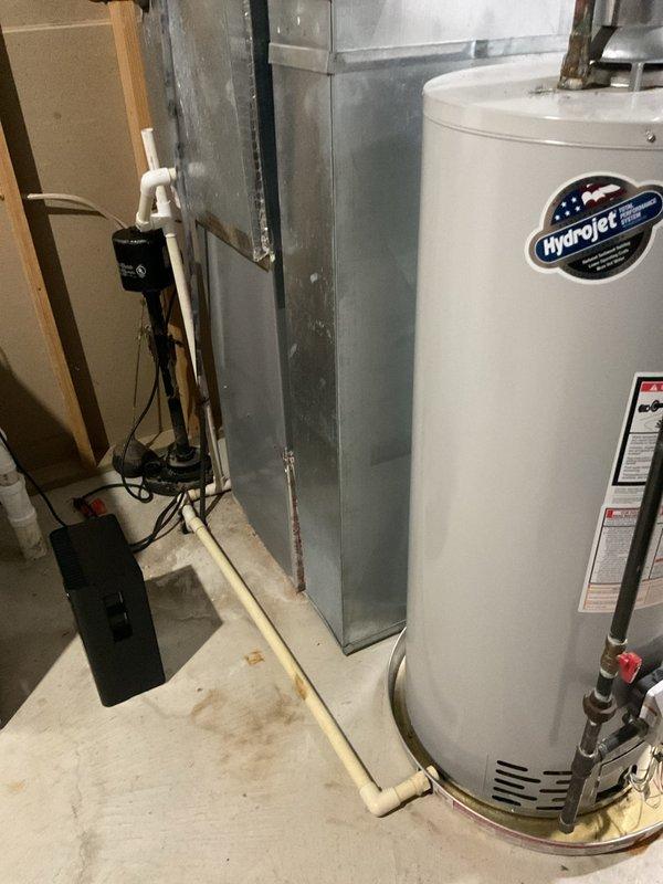 Responded to report of slow drip leak on 10-year-old Bradford White residential water heater. Upon inspection, unit was still operational with minor leak present at bottom connections. Documented equipment condition with photographs showing water heater installation, gas valve assembly, piping connections, and drain pan placement. Verified HydroJet total dissolved solids management system and assessed overall plumbing configuration including copper supply lines and safety valve assembly.
