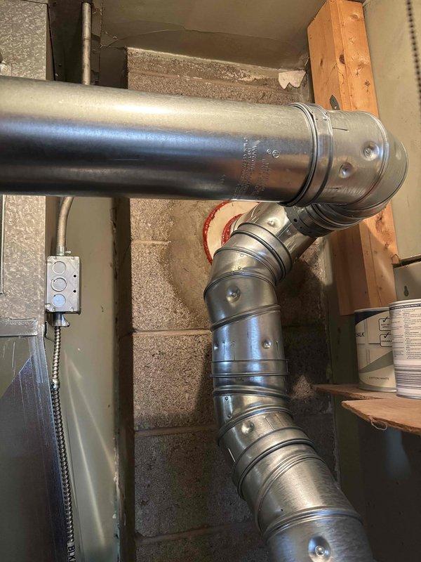Completed full furnace replacement in residential basement utility area. Removed existing heating unit and installed new Carrier brand furnace with proper clearances and ventilation connections. Connected metallic exhaust pipe vertically to existing ductwork system. Installed curved elbow joint with metal ductwork featuring proper coupling connections to integrate with home's HVAC distribution system. Verified all duct connections are secure and sealed. Confirmed adequate spacing around furnace and adjacent water heater per code requirements. Tested unit operation and airflow through system. Collected payment as authorized.