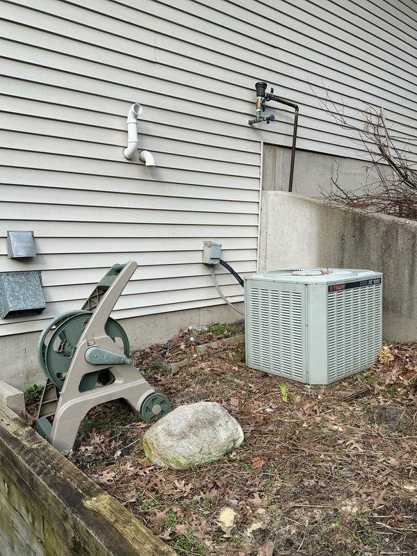 Conducted sales estimate for complete furnace replacement system. Evaluated existing HVAC installation in basement mechanical room, including current galvanized metal furnace/air handler unit with associated white PVC condensate drain lines and control components. Assessed exterior condensing unit positioned on concrete pad with connecting refrigerant lines and electrical service. Documented old discarded blower assembly and heating equipment components present on property exterior. Photographed current system configuration, clearances, ductwork connections, and existing PVC venting arrangement on building exterior. Provided comprehensive replacement options and equipment recommendations based on observed installation conditions and space constraints in utility area.