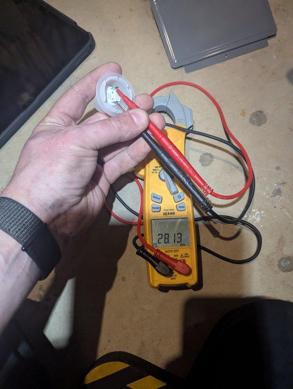 Responded to 9-year-old Rheem water heater displaying 7-blink error code after recent repair. Performed diagnostic testing using multimeter to measure voltage at heating element (701.2V reading) and tested capacitor functionality (28.13 reading). Error code indicated thermal cutoff or high limit switch fault, requiring component testing to isolate the issue and restore proper heating operation.