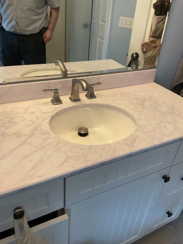 Responded to recurring drainage issue in bathroom where water backs up every couple of months. Performed cable snaking of drain line servicing shower and vanity sink to clear blockage and restore proper drainage flow. Verified both fixtures draining properly upon completion.