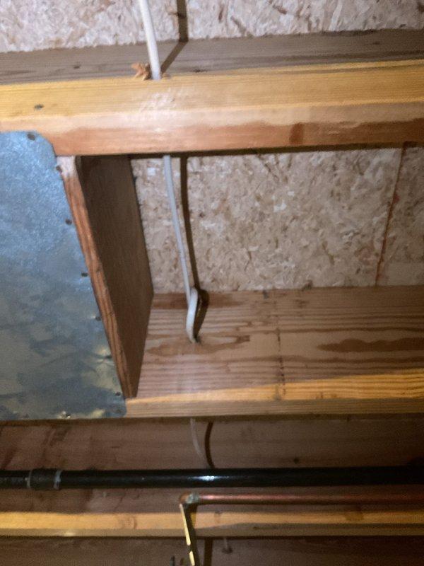 Responded to water leak in basement where pipe was dripping every 4-5 seconds. Inspected plumbing system including basement structural areas and under-sink cabinet connections. Documented existing plumbing configuration including PVC P-trap assembly, drain lines, and exposed piping. Photographed affected areas showing wooden framework, insulation, and plumbing components for service records.