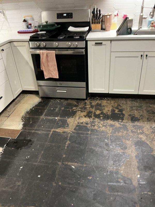 Responded to emergency plumbing leak that caused extensive water damage to kitchen flooring. Upon arrival, identified and repaired the source of the leak, then documented the resulting damage to the slate tile flooring, which showed significant deterioration with multiple tiles missing, exposed subflooring, and widespread surface wear throughout the kitchen area. The water intrusion had compromised both the tile adhesive and flooring material, requiring comprehensive photographic documentation for insurance purposes and future restoration work.
