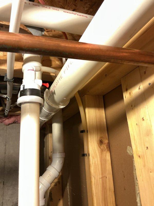 Responded to drainage issue affecting single drain related to water softener backflow in twelve-year-old residence. Upon inspection, identified improper drainage configuration in utility area where water softener discharge line was creating backflow conditions. Cleared obstruction from affected drain line, verified proper flow through PVC drainage system, and confirmed all connections were secure and functioning correctly. Documented plumbing configuration including water supply lines, drainage piping, and water softener installation with photographic evidence for service records.