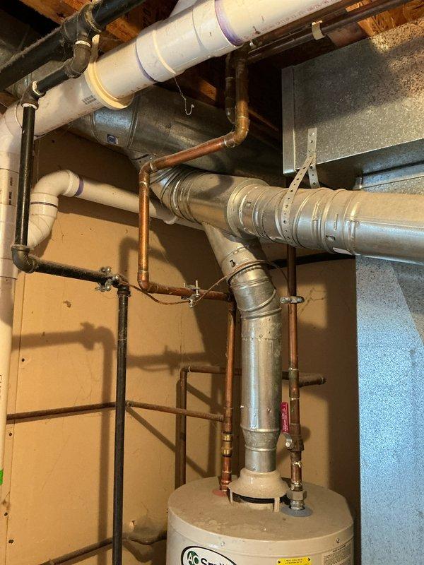 Provided estimate for replacement of original 2006 A.O. Smith water heater that has reached end of serviceable life at 20 years old. Documented existing installation including copper supply lines, galvanized metal flue pipe, and current positioning in basement utility area for accurate replacement specifications.