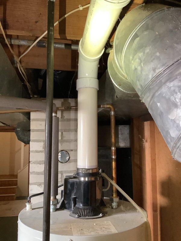 Provided estimate for water heater replacement in unfinished basement utility area. Existing unit is a standard residential water heater with visible plumbing connections, pressure relief valve, copper supply lines, and PVC condensate drainage system with pump assembly. Assessment included evaluation of current installation configuration, structural support requirements, and compatibility with existing plumbing infrastructure for potential replacement.