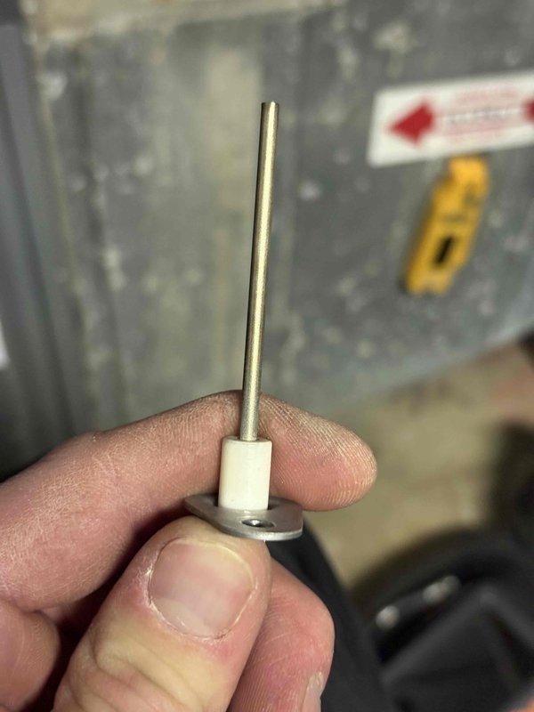 Completed annual heating maintenance on 9-year-old Amana furnace system per club membership agreement. Performed comprehensive tune-up including system inspection, cleaning, and safety checks. Identified failed flame sensor during inspection, as evidenced by heavy oxidation and carbon buildup on the sensor rod. Removed and photographed deteriorated sensor showing significant degradation of the probe element. Component failure would have prevented proper furnace operation and flame detection. Documented sensor condition with detailed photos showing the white ceramic base, threaded mounting assembly, and corroded metal sensing rod for service records.