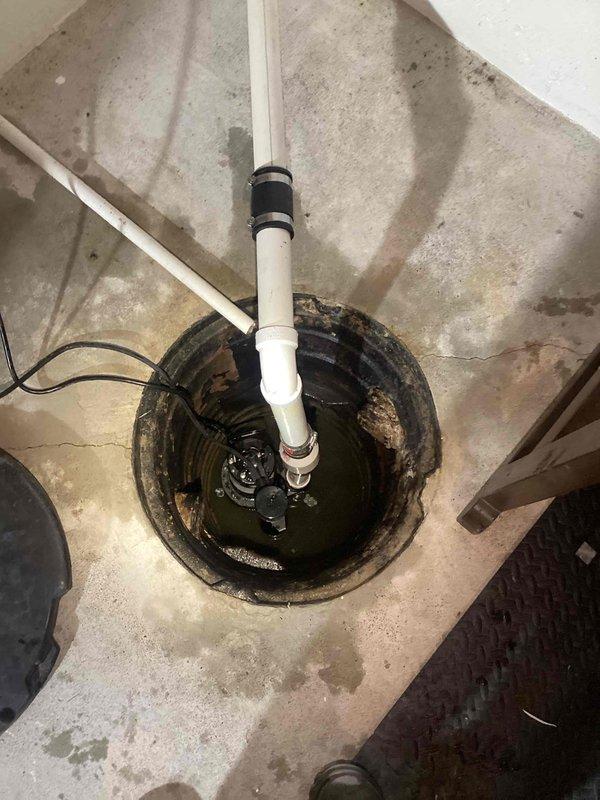 Replaced existing sump pump system in basement sump pit. Removed failed pump unit and installed new submersible sump pump with vertical PVC discharge piping and proper rubber coupling seal at pit exit point. Verified pump operation, tested float switch activation, and confirmed proper drainage through discharge line. System now operational and ready for automatic water removal.