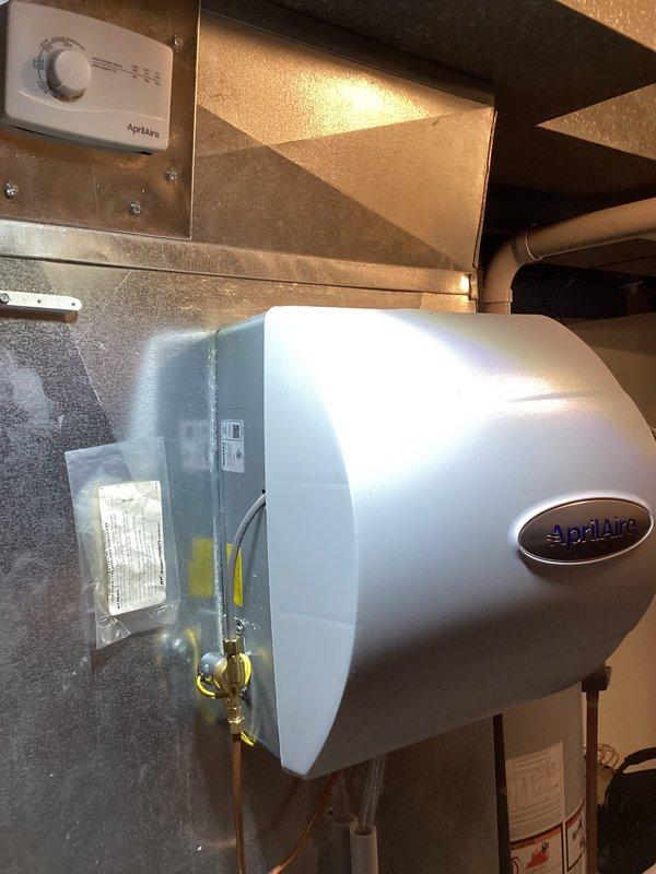 Completed annual heating maintenance on EnergiAir furnace and AprilAire humidifier system. Performed comprehensive tune-up including inspection of furnace components, ductwork with seasonal damper control, and copper refrigerant lines. Verified humidifier operation, control settings, and water supply connections with brass valves functioning properly. All equipment found in good working condition with standard residential installation throughout mechanical room.