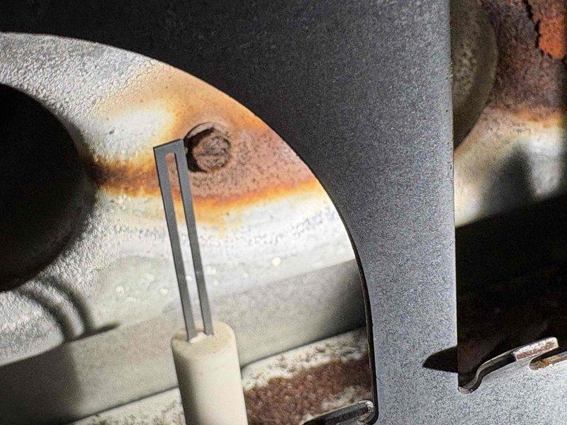 Completed annual heating tune-up on 12-year-old Goodman furnace system. During inspection, discovered significant corrosion and rust on burner assembly components and flame sensor rod. Removed deteriorated flame sensor, which showed heavy oxidation and buildup affecting system operation. Cleaned and reinstalled sensor, tested ignition sequence, and verified proper flame detection. System operating within normal parameters upon completion.