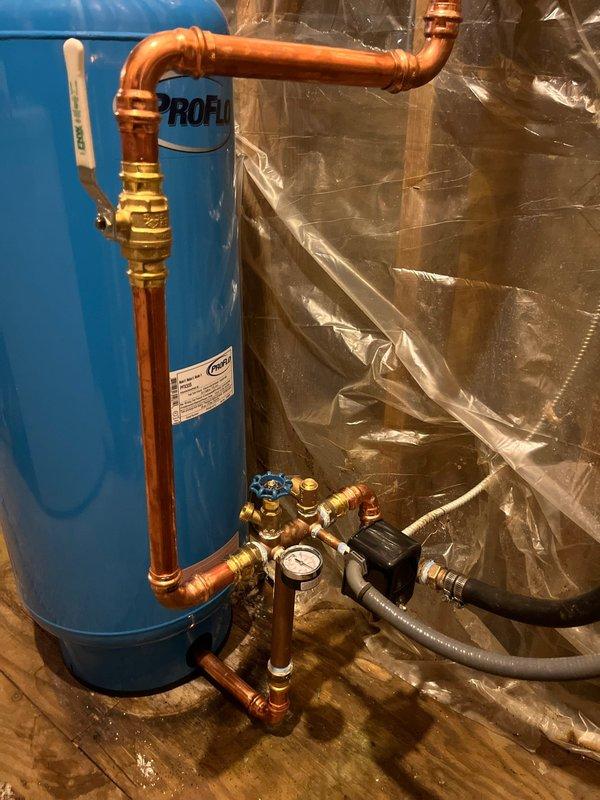 Completed full-day plumbing project installation including replacement of water pressure tank with new unit, complete with pressure switch, tee fittings, and brass valve assembly with integrated pressure gauge. Installed all new copper piping connections with proper brass fittings and shut-off valves to ensure system integrity. Mounted pressure tank on stable platform in basement utility area with proper clearances for maintenance access.

Installed customer-supplied kitchen faucet with connections to existing water supply lines, ensuring proper sealing and flow rates. Replaced shower valve assembly with new fixture, completing all rough-in connections and testing for leaks.

All installations tested and verified operational. System pressurized and checked for proper pressure regulation. Work completed with cleanup of workspace.