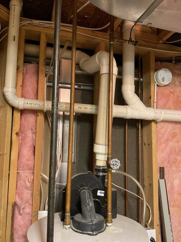 Conducted on-site water heater estimate for residential property. Evaluated existing Bradford White water heater installation in basement utility area, documenting current unit configuration, plumbing connections including copper hot and cold water lines with brass fittings, draft hood assembly, and surrounding mechanical systems. Assessed installation location within framed wall space with proper clearances, photographed existing conditions including PVC venting, electrical connections, and overall system layout to provide accurate replacement estimate.