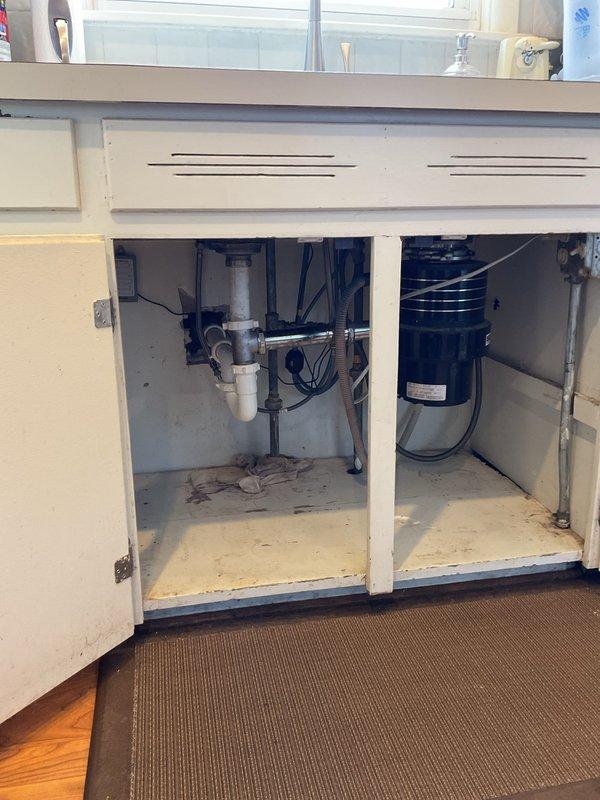 Responded to kitchen sink with low hot water pressure and leaking shutoff valve. Diagnosed sediment buildup in hot water supply line causing reduced flow; flushed line and inspected aerator for debris. Identified faulty shutoff valve with worn compression seal causing leak when closed; tightened packing nut and recommended valve replacement for permanent solution. Addressed secondary issue at bar sink where newly installed deeper basin was draining slowly; inspected P-trap configuration and determined improper slope in drain assembly. Adjusted drain pipes to achieve proper fall and verified improved drainage performance. Both sinks tested and operational upon completion.