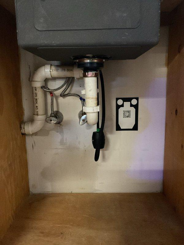Responded to kitchen sink with low hot water pressure and leaking shutoff valve. Diagnosed sediment buildup in hot water supply line causing reduced flow; flushed line and inspected aerator for debris. Identified faulty shutoff valve with worn compression seal causing leak when closed; tightened packing nut and recommended valve replacement for permanent solution. Addressed secondary issue at bar sink where newly installed deeper basin was draining slowly; inspected P-trap configuration and determined improper slope in drain assembly. Adjusted drain pipes to achieve proper fall and verified improved drainage performance. Both sinks tested and operational upon completion.