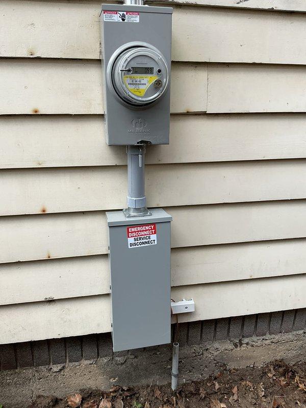 Completed 200-amp electrical service upgrade on residential property. Coordinated utility company power disconnect and reconnect, obtained electrical permit, and installed new Milbank meter socket enclosure with emergency service disconnect panel mounted on exterior wall with gray conduit connecting components. Notified homeowner of scheduled power outage, arranged municipal inspection, and restored full electrical service upon completion and approval.