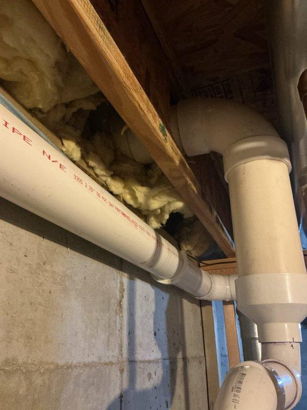 Responded to emergency water leak call in basement area. Upon arrival, located active leak from PVC piping installed in wall cavity above water heater. Inspected horizontal and vertical PVC supply lines running through exposed ceiling joists and along foundation wall. Identified source of dripping water affecting water heater unit below. Documented existing plumbing configuration including pipe specifications and placement. Assessed surrounding area for water damage to insulation, structural framing, and concrete foundation. Photographed leak location and affected components for record. Set up fans to begin drying process in affected basement space.