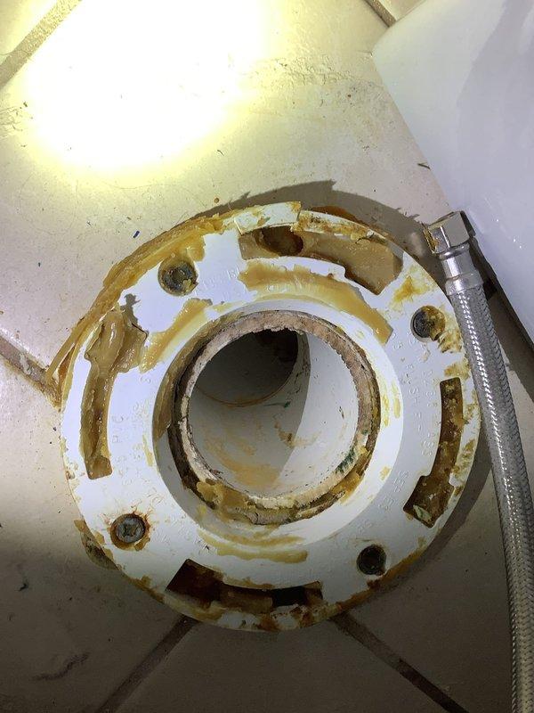 Replaced deteriorated toilet wax ring and mounting flange due to severe rust and corrosion around bolt holes and perimeter. Removed toilet, installed new wax ring and flange assembly, reset toilet to proper position, and verified secure mounting and proper seal to prevent future leaks.