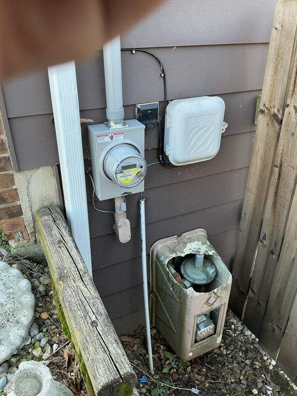 Conducted electrical estimate for replacement of original 1970s electrical panel in basement of single-family home with two failed circuit breakers. Inspected existing gray panel box mounted on light green painted concrete wall in unfinished basement area, documented deteriorated breakers and overall panel condition. Assessed installation requirements including access to service entrance, existing conduit routing through exposed ceiling joists, and connection points to exterior meter box with white PVC conduit runs. Photographed current electrical infrastructure to provide comprehensive replacement quote for full panel upgrade to meet current code requirements and restore safe electrical service to affected circuits.