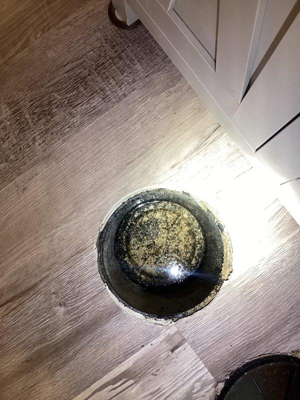 Responded to report of possible leak in basement bathroom of 1967-built home where leak had been noticed for two days following a 2023 bathroom remodel. Upon arrival, accessed floor openings to investigate plumbing connections and discovered significant buildup, discoloration, and staining on drain assembly and surrounding areas. Inspected exposed plumbing fixtures through floor access points, documented conditions with photos showing mineral deposits, grime accumulation, and water damage indicators around drain components. Assessed integrity of recently remodeled bathroom plumbing connections and identified source of reported leak.