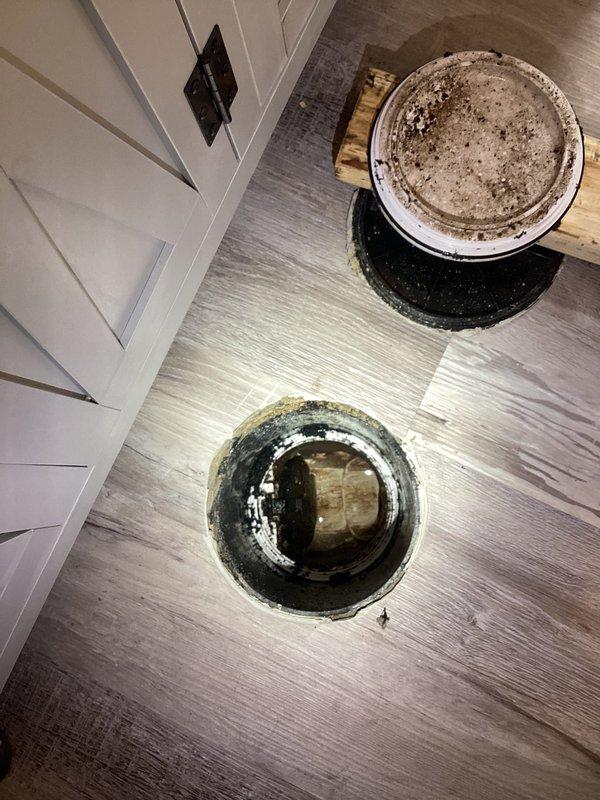 Responded to report of possible leak in basement bathroom of 1967-built home where leak had been noticed for two days following a 2023 bathroom remodel. Upon arrival, accessed floor openings to investigate plumbing connections and discovered significant buildup, discoloration, and staining on drain assembly and surrounding areas. Inspected exposed plumbing fixtures through floor access points, documented conditions with photos showing mineral deposits, grime accumulation, and water damage indicators around drain components. Assessed integrity of recently remodeled bathroom plumbing connections and identified source of reported leak.