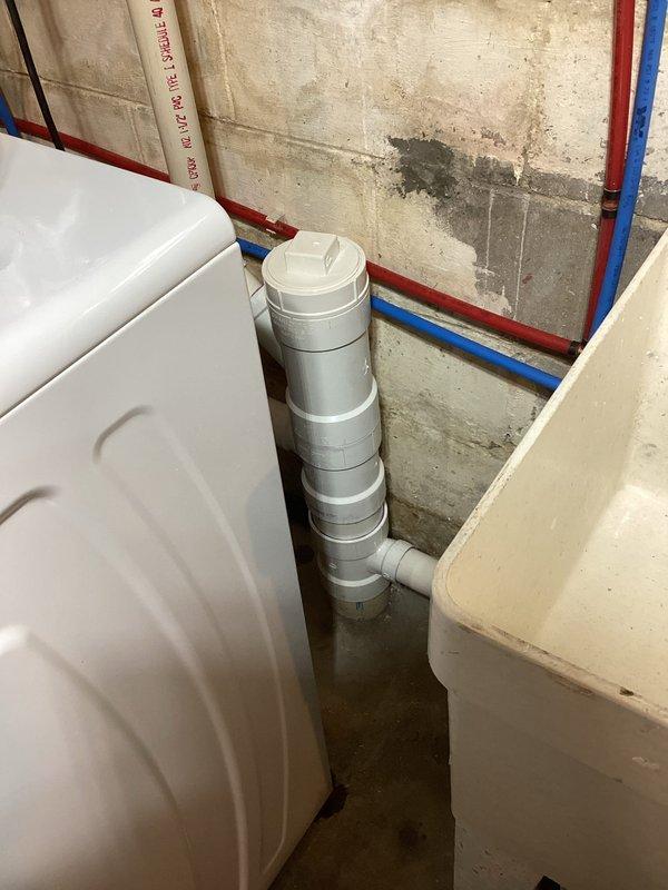 Removed existing improperly configured washing machine drain lines in utility room. Installed new dedicated P-traps for both washing machine and utility sink, with each fixture independently tied into the existing 4-inch drain stack to ensure proper drainage and code compliance.