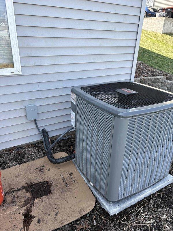 Completed full HVAC system installation including new residential furnace and outdoor air conditioning condenser unit. Furnace installed in basement utility area on protective base pad with proper PVC venting and condensate drainage system, metallic supply trunk ductwork connected and secured. Exterior AC condenser positioned on concrete pad with refrigerant lines run to house, electrical disconnect box mounted, and unit tested for proper operation.