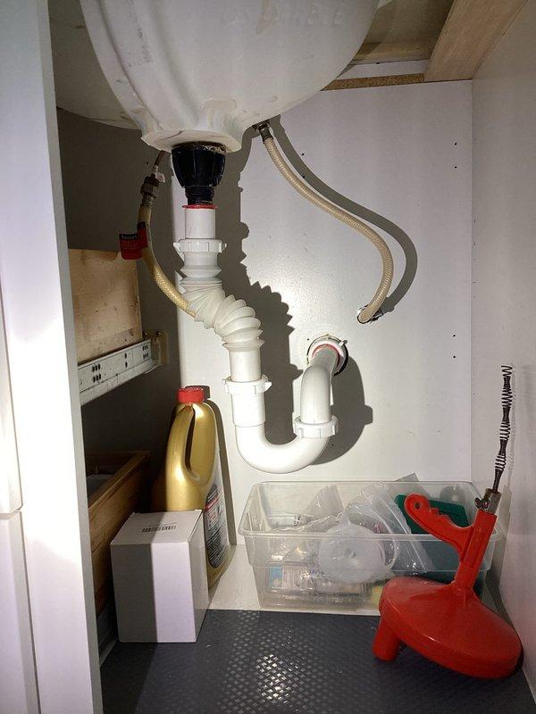 Responded to service call for dripping laundry room faucet and persistent odor from household drains. Inspected dual-handle chrome faucet at laundry sink and examined drain system beneath sink, including P-trap configuration and PVC plumbing connections. Addressed dripping faucet issue and assessed drain system for source of recurring foul odors affecting all sinks throughout the residence.