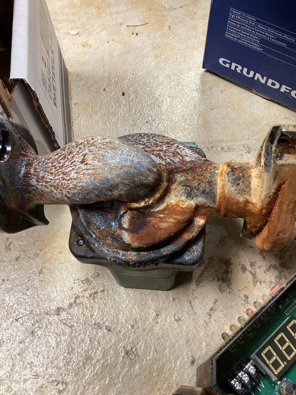 Replaced failed circulator pump on hydronic heating system. Removed heavily corroded pump assembly with deteriorated piping connections showing extensive rust and oxidation damage. Installed new Grundfos circulator pump with proper copper piping connections and brass fittings. Verified proper pump operation and system flow upon completion.