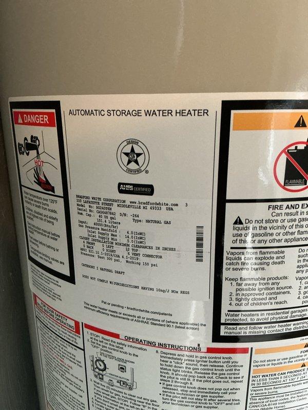 Completed installation of a 40-gallon natural gas water heater, tall model, manufactured by Bradford White. Connected copper supply lines with compression fittings and shut-off valves, installed galvanized metal venting ductwork with proper elbow configuration for exhaust, and ensured brass drain valve accessibility. All safety labels, manufacturer specifications, and warning placards were verified in place, and unit was tested for proper operation and compliance with code requirements.