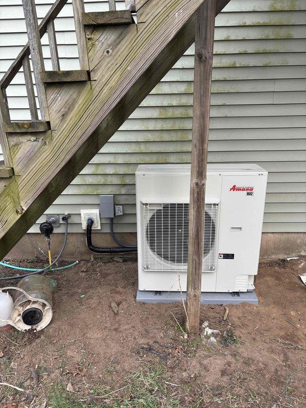 Completed full furnace and air conditioning system installation at residential property. Installed new Amana outdoor condensing units on concrete pad with proper refrigerant line sets, electrical connections, and conduit routing along exterior wall. All equipment mounted, connected, and operational per manufacturer specifications.