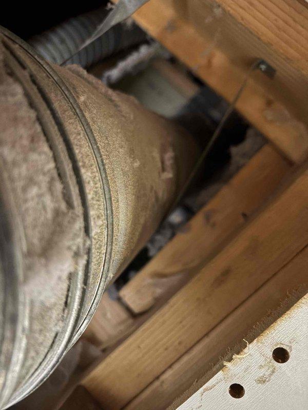 Responded to inspector correction notice regarding improper B-vent clearance. Corrected installation where B-vent pipe was installed with insufficient clearance to combustible materials, ensuring proper 1-inch minimum clearance between vent pipe and wall/plastic components per code requirements. Retrieved cordless drill left on site by installation crew and documented corrected clearances with photos.