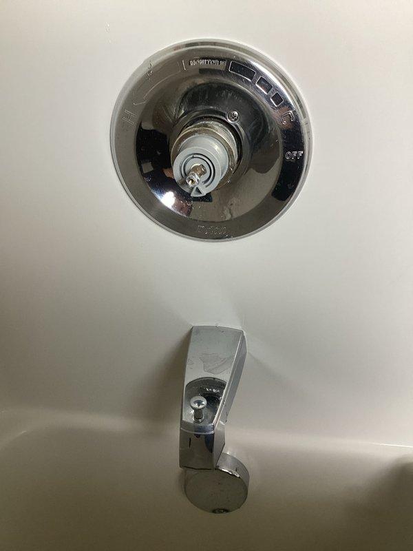 Responded to upstairs bathroom shower with inadequate hot water delivery and restricted temperature control operation. Upon inspection, found shower diverter valve mechanism preventing full rotation toward hot water setting, limiting water temperature to lukewarm maximum. Disassembled chrome shower control fixture to access internal valve assembly and ceramic cartridge components. Assessed valve stem and trim plate assembly for mechanical obstruction and proper range of motion. Documented existing installation showing single-handle temperature control valve with visible wear and potential internal component failure affecting hot water flow regulation. Photographed fixture configuration including tub spout and control valve positioning on tiled wall for service records.