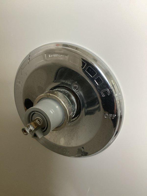 Responded to upstairs bathroom shower with inadequate hot water delivery and restricted temperature control operation. Upon inspection, found shower diverter valve mechanism preventing full rotation toward hot water setting, limiting water temperature to lukewarm maximum. Disassembled chrome shower control fixture to access internal valve assembly and ceramic cartridge components. Assessed valve stem and trim plate assembly for mechanical obstruction and proper range of motion. Documented existing installation showing single-handle temperature control valve with visible wear and potential internal component failure affecting hot water flow regulation. Photographed fixture configuration including tub spout and control valve positioning on tiled wall for service records.