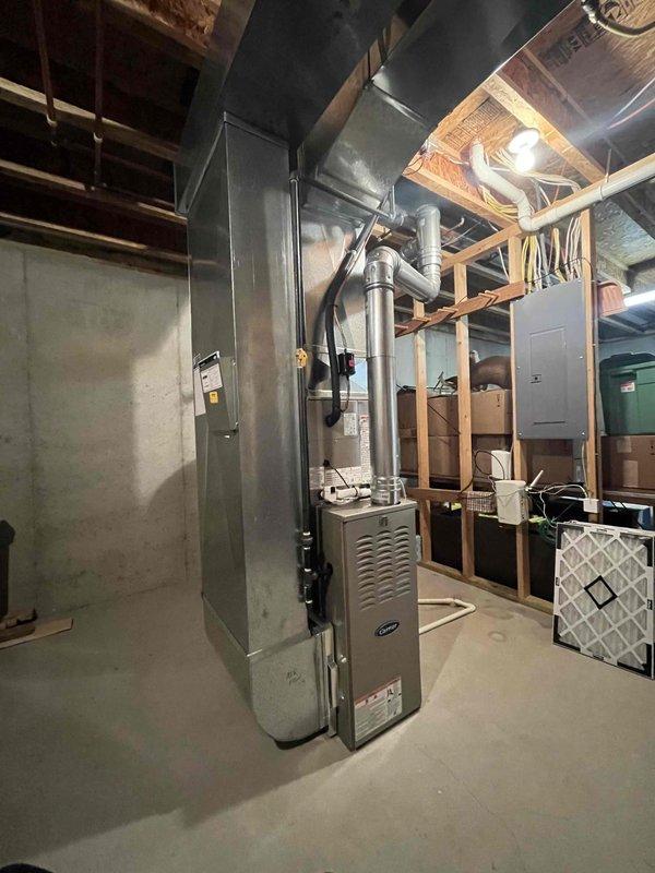 Completed full HVAC system installation including Carrier brand furnace unit with metallic ductwork and plenum connections, air conditioning system, and Bradford White 40-gallon natural gas water heater (40,000 BTU/H input rating). All equipment installed in basement utility area with proper venting, ductwork routing through ceiling joists, electrical connections, and gas line hookups per manufacturer specifications and code requirements. System tested and operational upon completion.