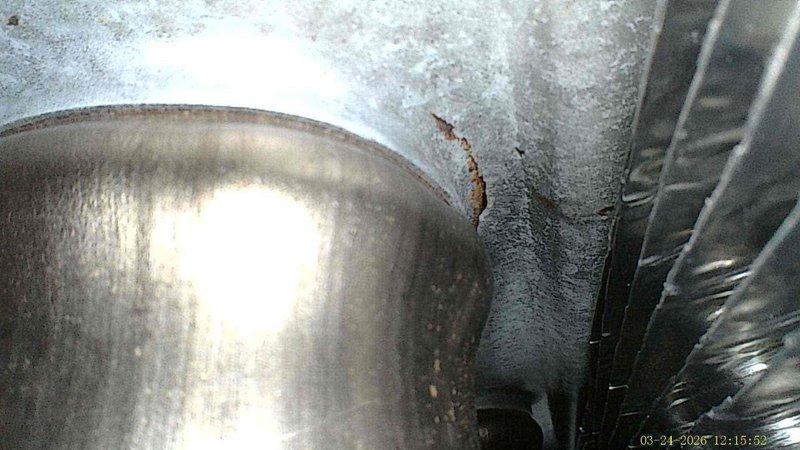 # AC Annual Cooling Visit - Daikin System

Completed annual maintenance inspection on 2-year-old Daikin air conditioning system. Upon arrival, discovered severe frost and ice accumulation throughout the evaporator coil and air handler cabinet, indicating a significant operational issue requiring immediate attention beyond routine maintenance.

Identified extensive ice buildup on evaporator coil surfaces and surrounding metal panels, with frost extending across ductwork and internal components. Observed moisture-related corrosion and rust formation on metal surfaces and joints within the air handler unit. The heavy frost accumulation suggested either refrigerant flow restriction, low refrigerant charge, insufficient airflow across the coil, or possible thermostat cycling issues.

Documented system conditions with photographic evidence showing crystalline ice formations covering evaporator surfaces and condensation damage to surrounding metalwork. The cylindrical liquid line and suction 