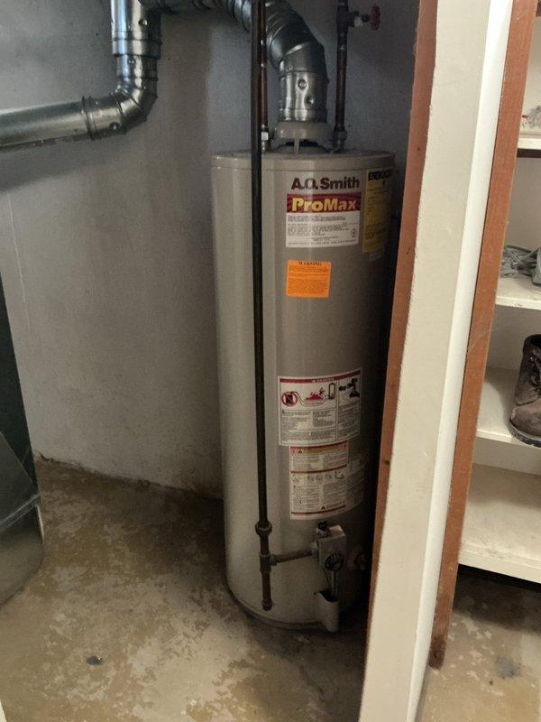 Conducted on-site assessment of existing A.O. Smith ProMax tank-style water heater installation in residential utility area to provide comprehensive estimate for water heating system replacement options. Documented current equipment configuration, including gas supply lines, venting system with flexible ductwork, plumbing connections, and spatial constraints within the utility closet to evaluate feasibility of both traditional tank-type and tankless water heater installations.