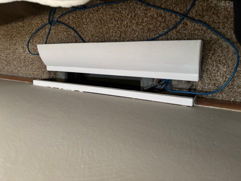 Responded to heating complaint regarding newly installed furnace not providing adequate heat to bedroom. Upon arrival, found baseboard heating unit with compromised cover and Emerson digital thermostat displaying 77°F setpoint with 52°F actual temperature, indicating significant temperature differential. Inspected baseboard heater installation, identified heating element accessibility issues, and documented system configuration. Verified thermostat programming and system operation to determine cause of insufficient heat delivery to affected zone.