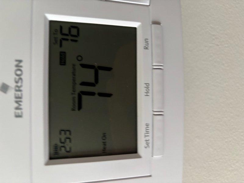 Responded to heating complaint regarding newly installed furnace not providing adequate heat to bedroom. Upon arrival, found baseboard heating unit with compromised cover and Emerson digital thermostat displaying 77°F setpoint with 52°F actual temperature, indicating significant temperature differential. Inspected baseboard heater installation, identified heating element accessibility issues, and documented system configuration. Verified thermostat programming and system operation to determine cause of insufficient heat delivery to affected zone.