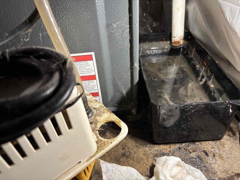 Completed annual heating maintenance on an 18-year-old Goodman furnace system without humidifier. Performed comprehensive tune-up including inspection of all mechanical components, burner assembly, heat exchanger, blower motor, and electrical connections. Noted moisture accumulation in drain pan and condensation on unit exterior, with visible water staining on base surface indicating ongoing drainage conditions. All safety controls tested and verified operational, system cycling properly with no immediate concerns identified.